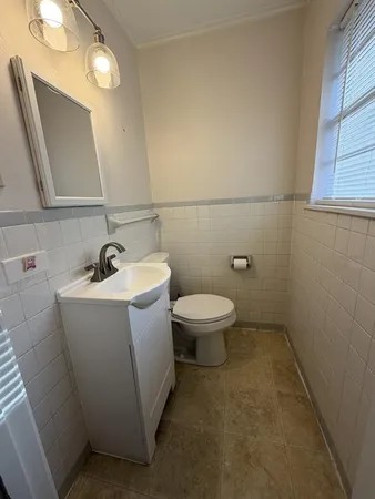 a bathroom with a sink and mirror with toilet