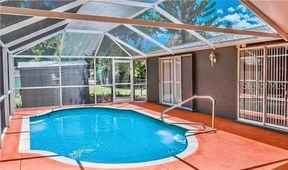 a backyard of a house with wooden floor and outdoor seating