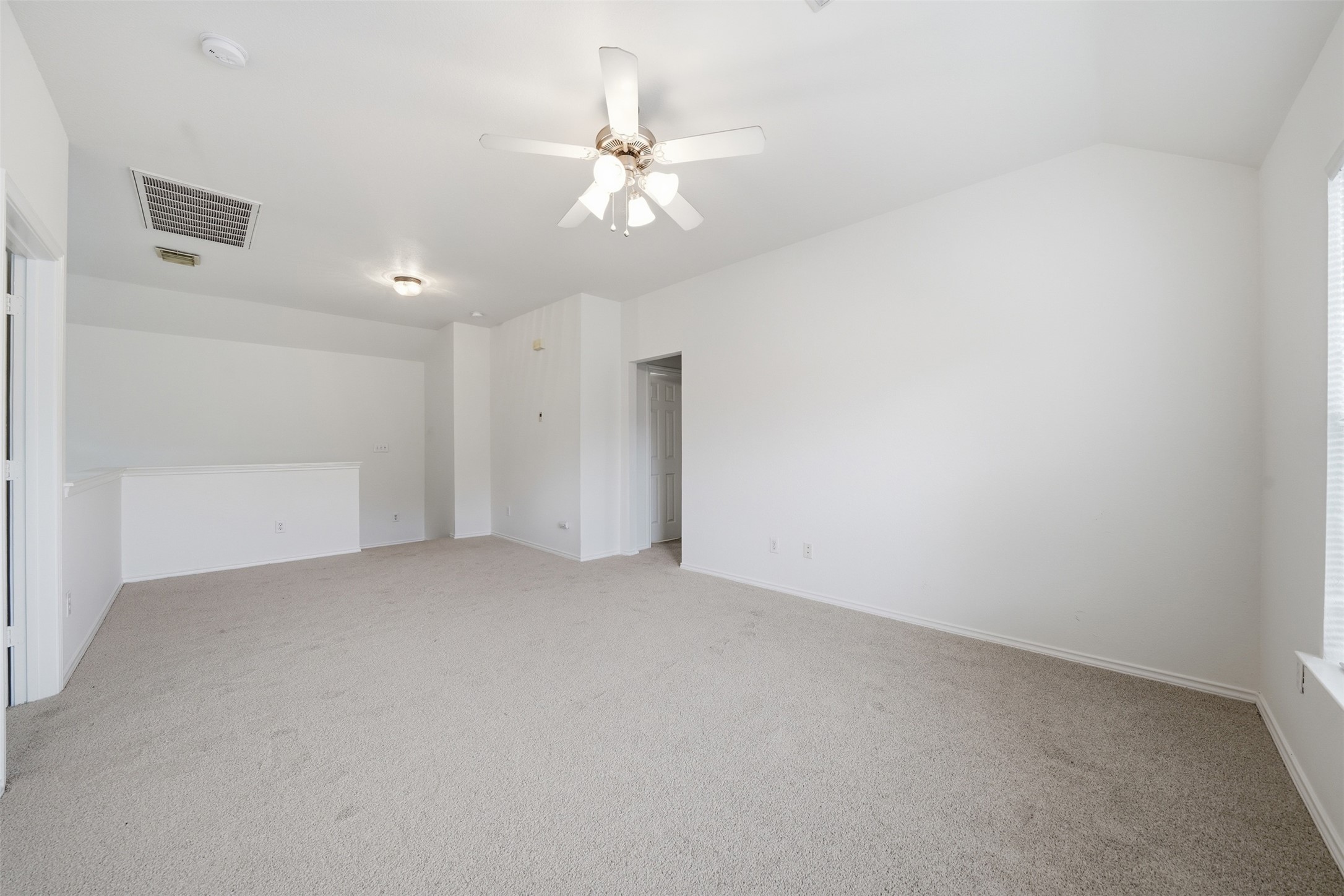 118 Invierno Street Kyle, TX 78640 - Photo 22 of 37 A spacious, naturally illuminated room featuring soft carpeting and a ceiling fan for comfort.