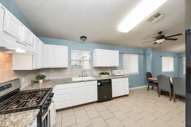 a kitchen with stainless steel appliances granite countertop a sink stove and cabinets