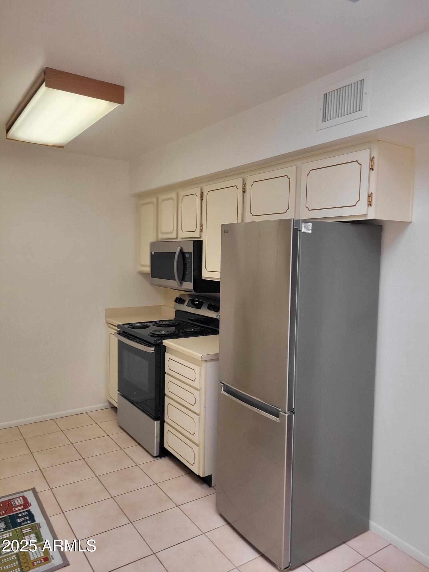 10060 West Royal Oak Road, Unit B Sun City, AZ 85351 - Photo 13 of 26 a white refrigerator freezer sitting in a kitchen