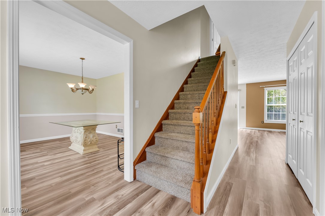25861 Kennedy Ridge Road North Olmsted, OH 44070 - Photo 6 of 24 Staircase featuring wood finished floors, baseboards, and a chandelier