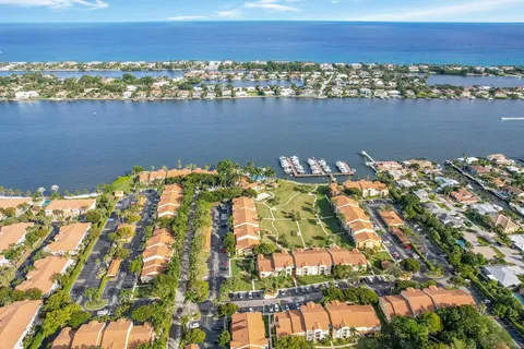 an aerial view of ocean and residential houses with outdoor space