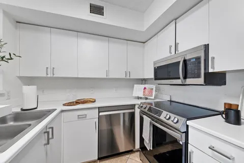 a kitchen with stainless steel appliances granite countertop a sink stove and microwave