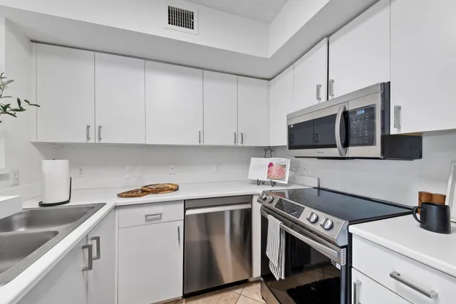 a kitchen with stainless steel appliances granite countertop a sink stove and microwave