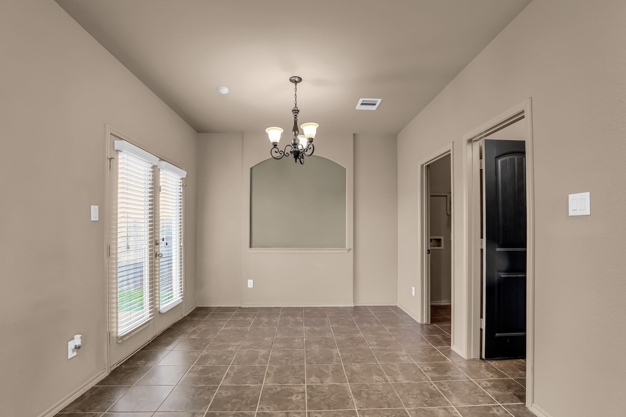 21307 Carleen Creek Trail Spring, TX 77379 - Photo 8 of 25 This dining area features neutral-colored walls, tile flooring, and abundant natural light from large windows with blinds. A stylish chandelier provides overhead lighting, and the space offers access to adjacent rooms and a patio through a set of doors.