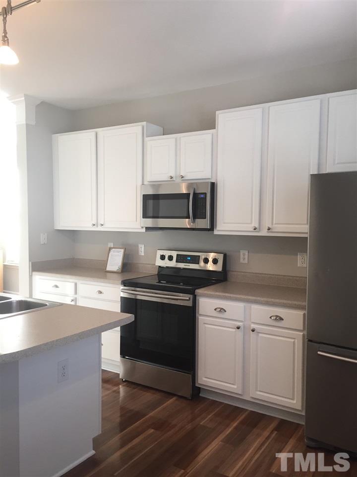8499 Central Drive Raleigh, NC 27613 - Photo 4 of 4 a kitchen with white cabinets stainless steel appliances and sink