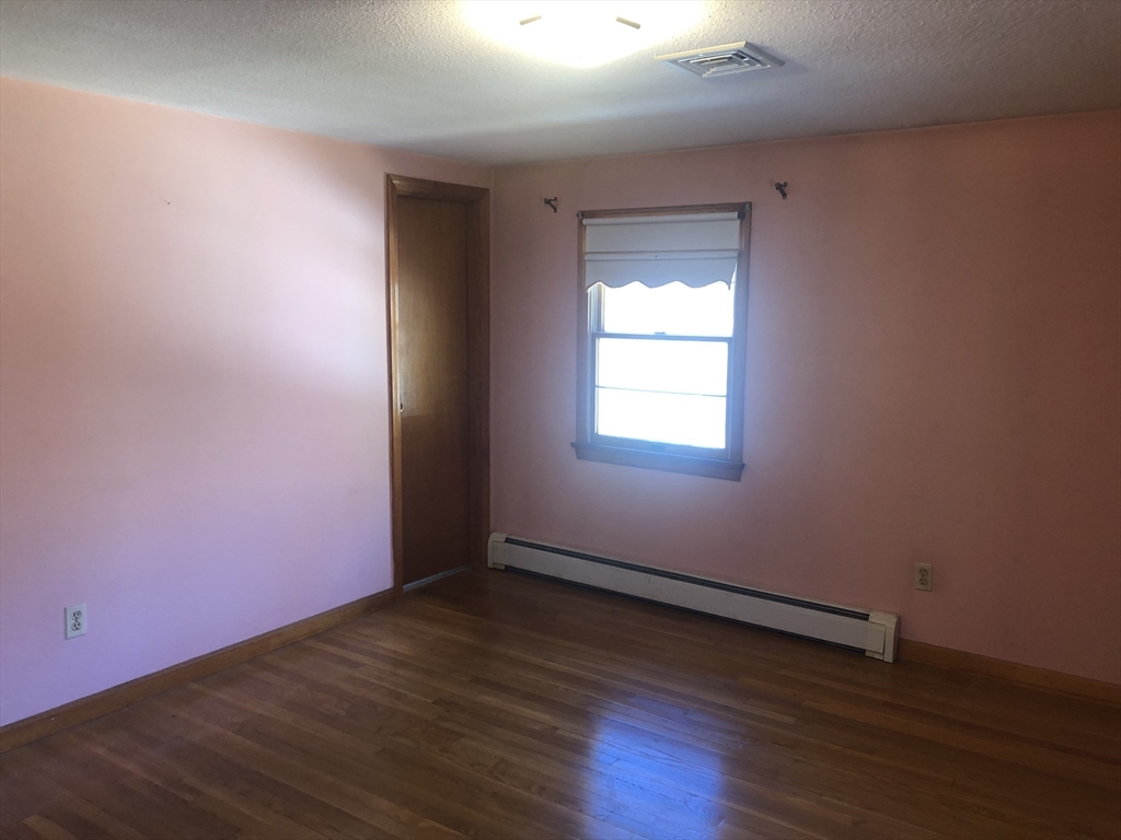 521 Franklin Street Whitman, MA 02382 - Photo 12 of 30 an empty room with wooden floor and windows