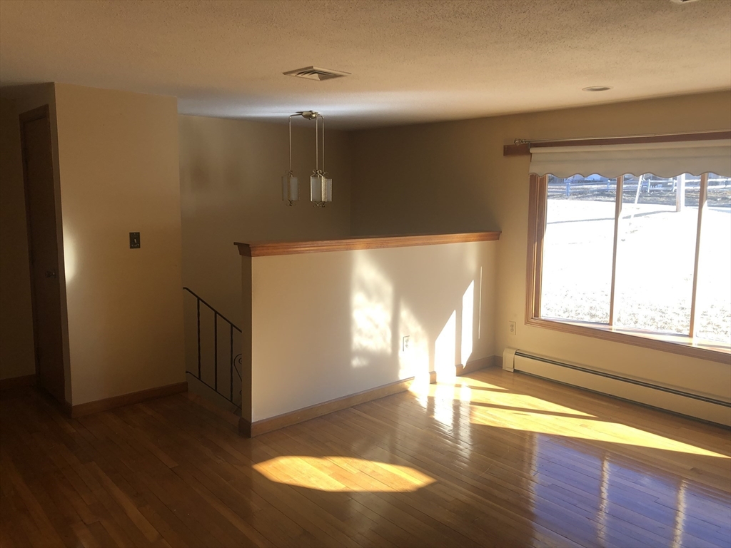521 Franklin Street Whitman, MA 02382 - Photo 7 of 30 a view of empty room with wooden floor and fan