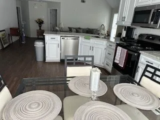 a kitchen with a table chairs stove and sink