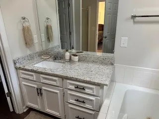 a bathroom with a granite countertop sink and a mirror