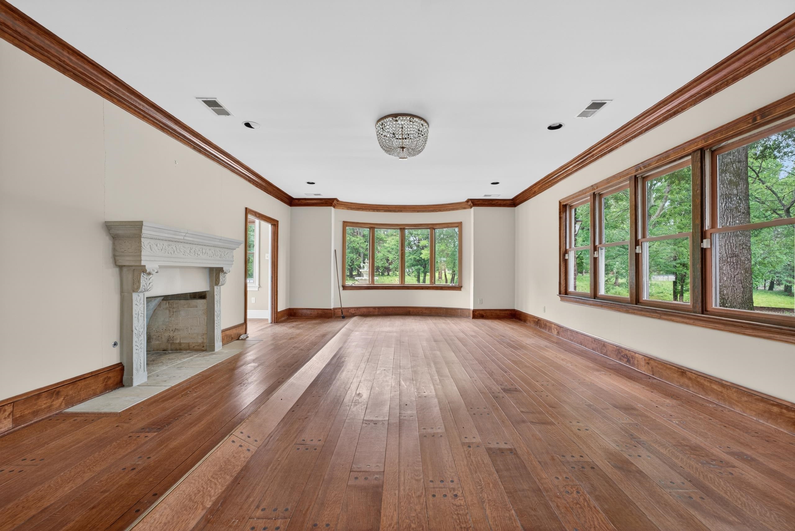 530 West Raines Road Memphis, TN 38109 - Photo 20 of 38 Spacious interior featuring wide plank wood-finish flooring, a decorative stone fireplace surround, extensive wood trim, and a bay window
