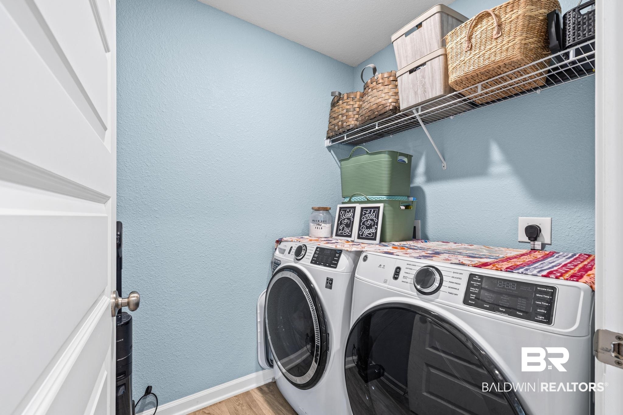 3078 Camino Real Loop Lillian, AL 36549 - Photo 23 of 51 Laundry room featuring a textured wall, washing machine and clothes dryer, and light wood-style flooring