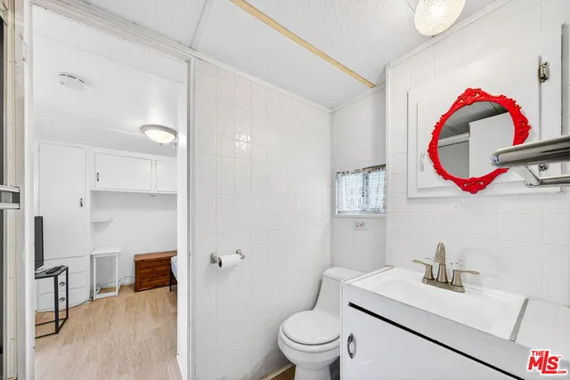 a bathroom with a sink vanity mirror and toilet