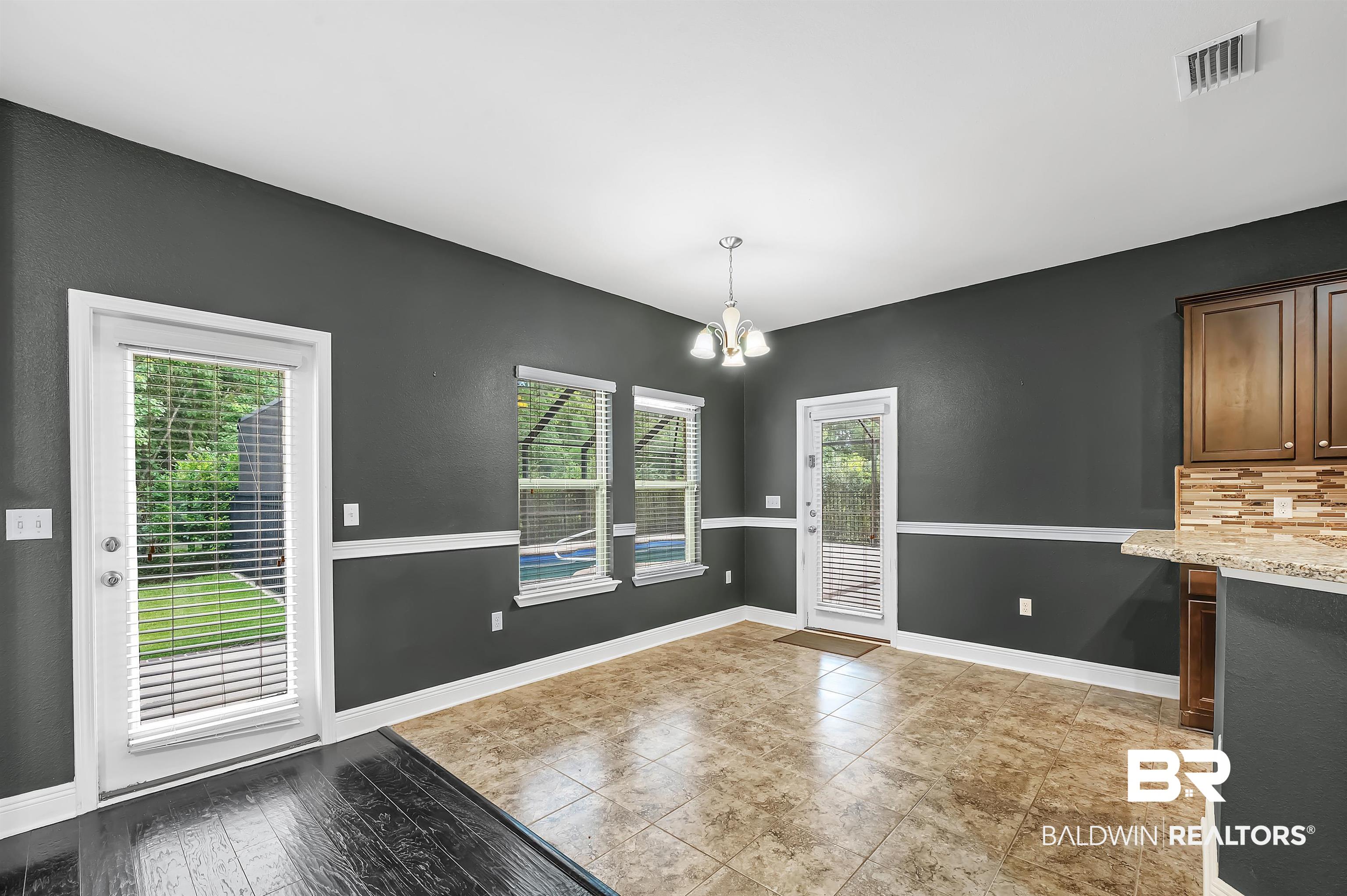 1086 Melbourne Court Foley, AL 36535 - Photo 15 of 43 Unfurnished dining area featuring light tile patterned flooring and a chandelier