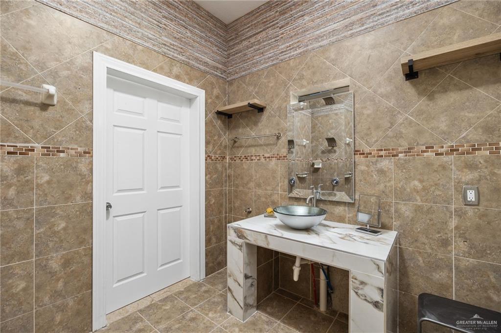 5056 Mile 8 Road Edinburg, TX 78541 - Photo 13 of 34 a bathroom with a granite countertop shower a sink and a mirror