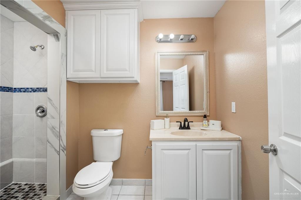 5056 Mile 8 Road Edinburg, TX 78541 - Photo 25 of 34 a bathroom with a granite countertop sink toilet and shower