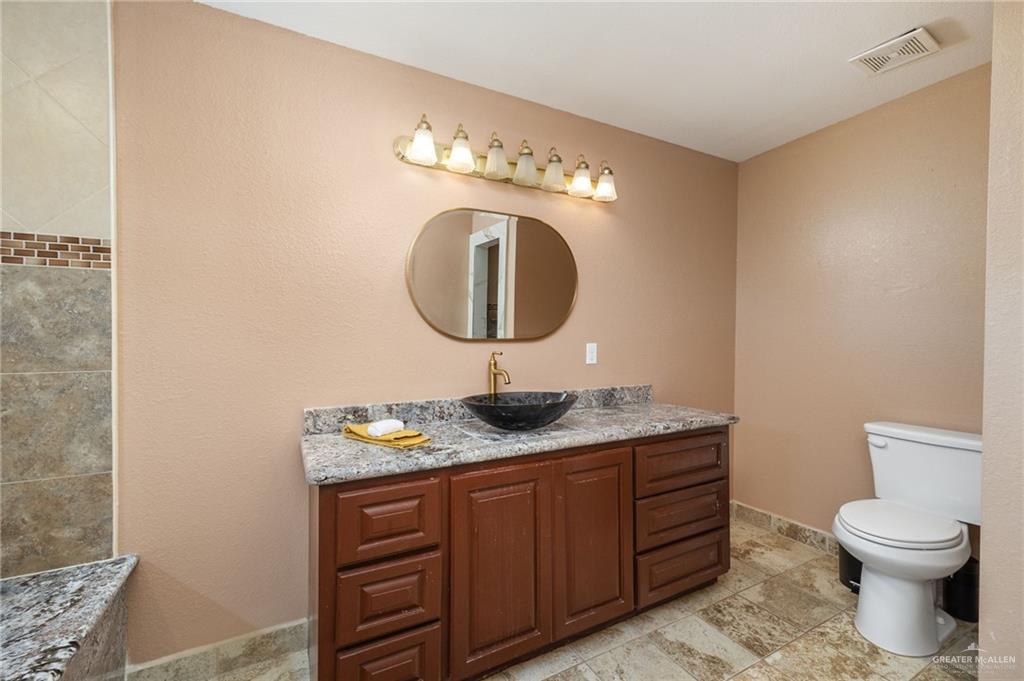 5056 Mile 8 Road Edinburg, TX 78541 - Photo 29 of 34 a bathroom with a granite countertop sink and a mirror