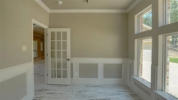 a view of an empty room with wooden floor and windows