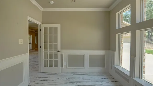 a view of an empty room with wooden floor and windows