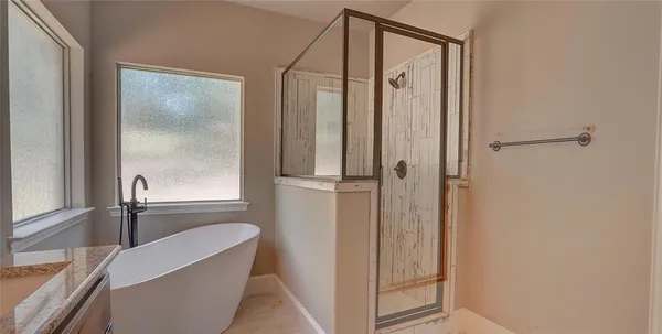 a bathroom with a granite countertop sink a mirror and a shower