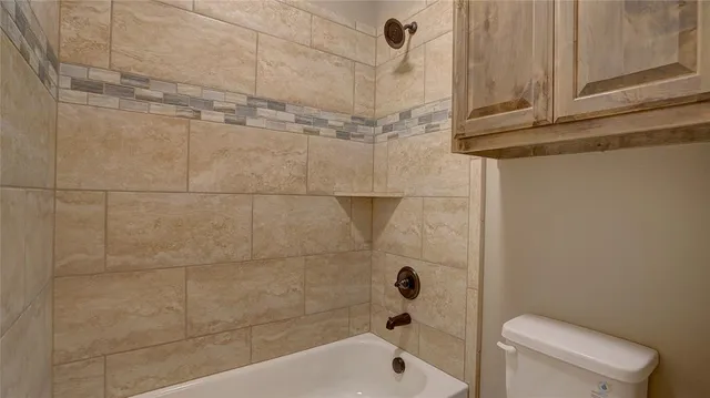 a view of an empty room with window and chandelier fan