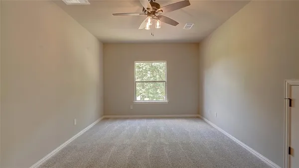 an empty room with a window and a fan