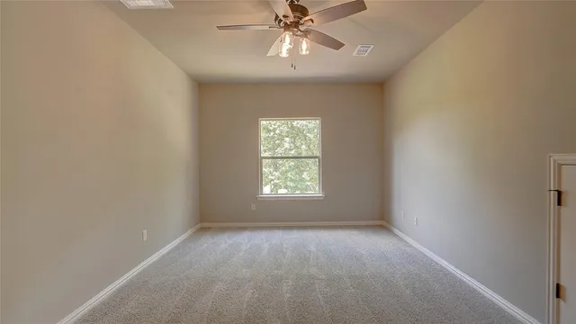 an empty room with a window and a fan