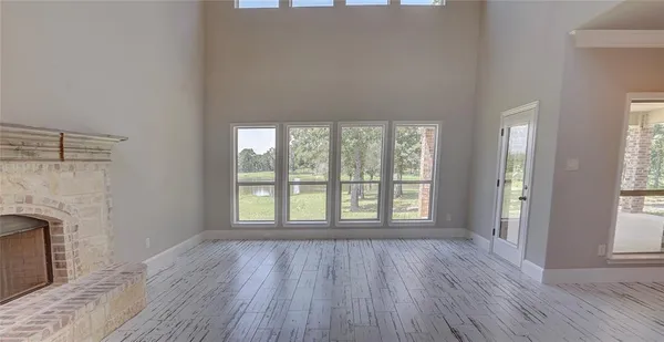 wooden floor fireplace and windows in an empty room