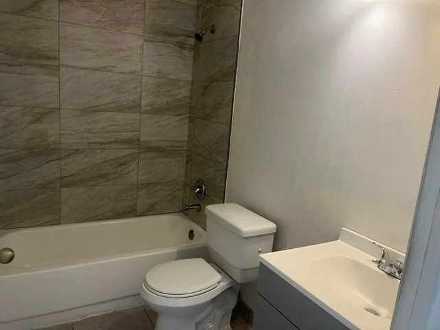 a white toilet sitting next to a bath tub and a shower