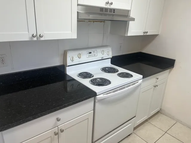 a kitchen with white cabinets and white appliances
