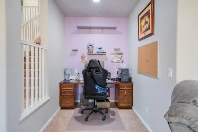 a view of a workspace with furniture and a window