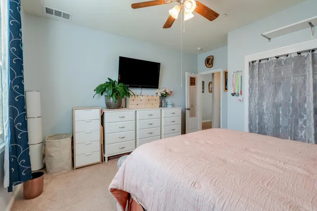 a bedroom with a large bed and a flat tv screen on dresser