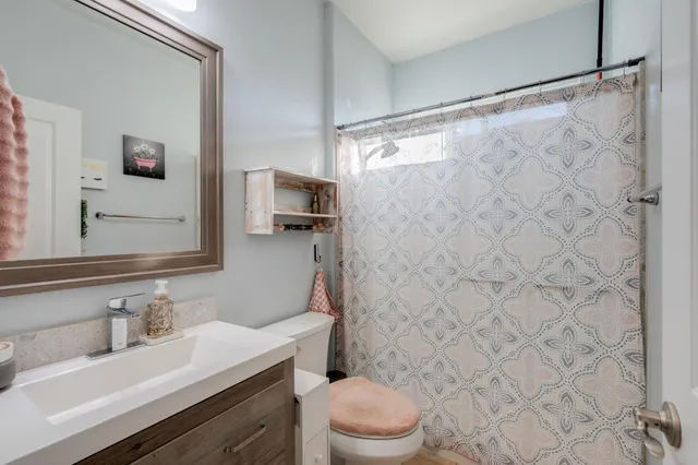 a bathroom with a sink toilet vanity and shower