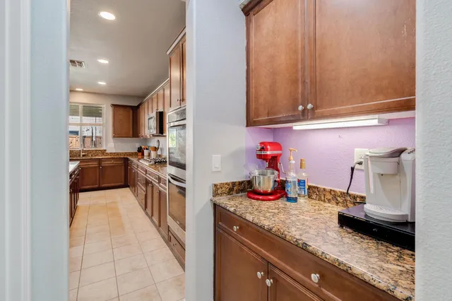 a kitchen with granite countertop a sink stove and cabinets