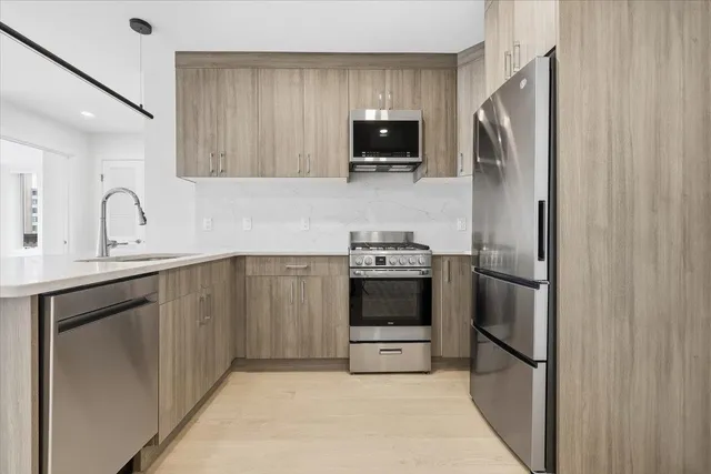 a kitchen with stainless steel appliances a refrigerator stove and microwave