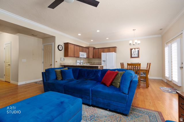 6761 950 East Midvale, UT 84047 - Photo 8 of 44 Open-concept living area with wood-finish flooring, crown molding, and a ceiling fan