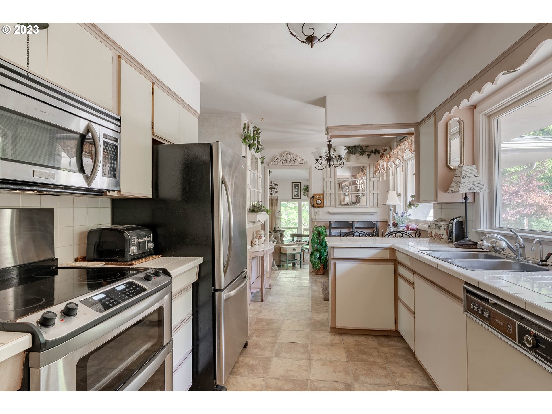 12750 Clow Corner Road Dallas, OR 97338 - Photo 20 of 43 a kitchen with stainless steel appliances a sink cabinets and a window
