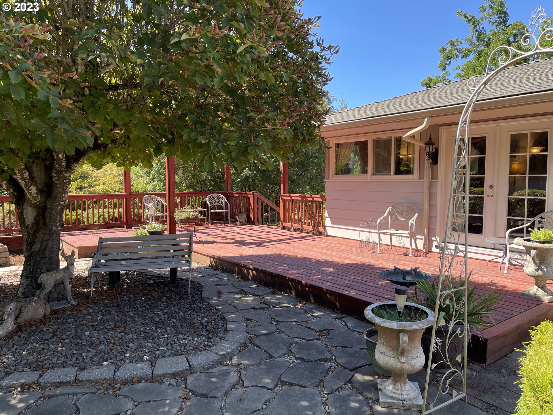 12750 Clow Corner Road Dallas, OR 97338 - Photo 24 of 43 a view of a backyard with table and chairs potted plants and a large tree