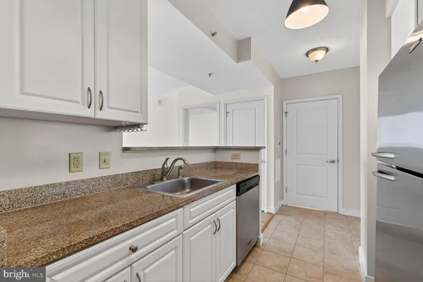 a kitchen with stainless steel appliances white cabinets and a stove top oven