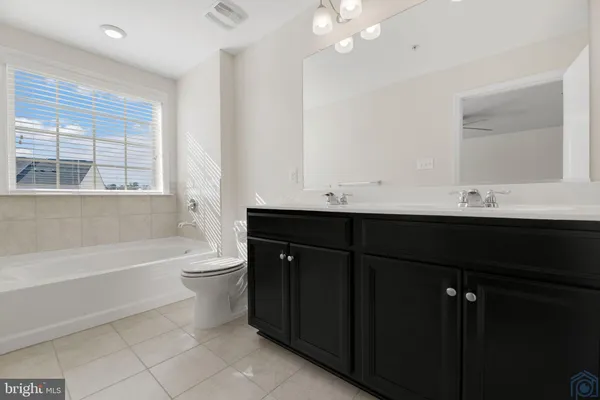 a bathroom with a sink a large mirror and a bathtub