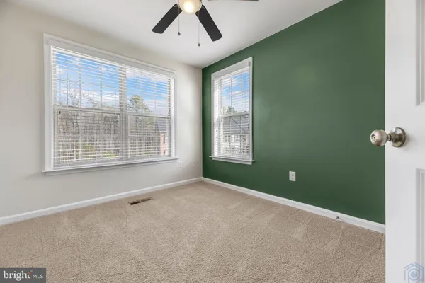 a view of an empty room with a window and a kitchen