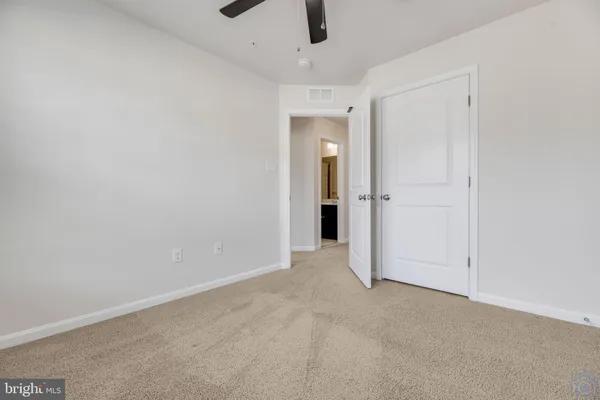 an empty room with chandelier fan
