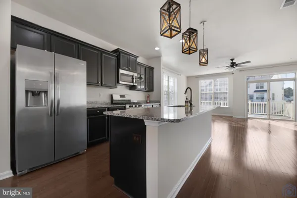 a kitchen with stainless steel appliances granite countertop a refrigerator and a stove top oven