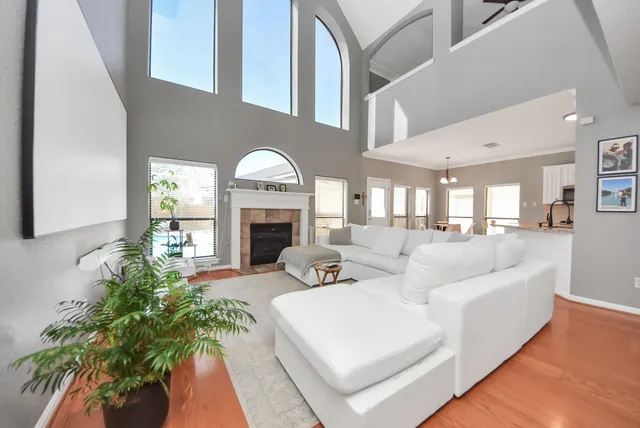 a living room with furniture a large window and a fireplace