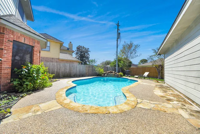 a view of a backyard with chairs potted plants and a wooden fence