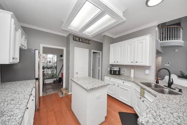 a kitchen with granite countertop a sink stove and cabinets
