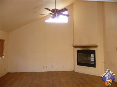 34454 Red Rover Mine Road Acton, CA 93510 - Photo 4 of 10 an empty room with a fireplace and a ceiling fan