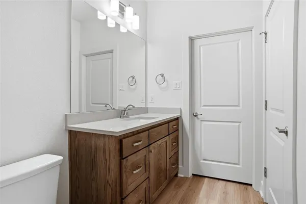 a bathroom with a granite countertop sink a toilet and a mirror