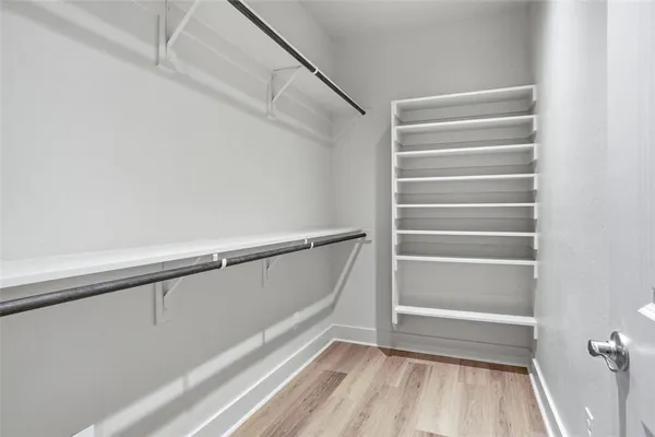 a view of walk in closet with empty racks